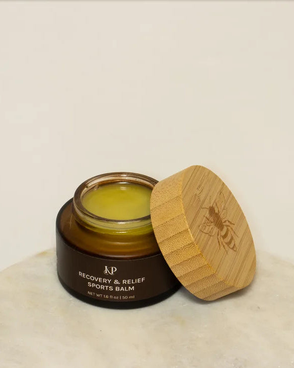 Sports balm jar with wooden lid on a marble surface
