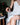Woman applying cream to her leg with a jar of cream on a table next to her.